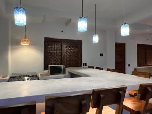 a kitchen with a large table with chairs and lights at Casa Jubilee king suite 2 in Puerto Escondido