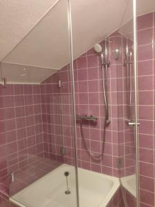ein lila gefliestes Bad mit einer Dusche und einer Badewanne in der Unterkunft Ferienwohnung #3 Harzblick mit Sauna in Oberwössen