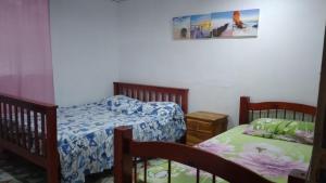 a bedroom with two twin beds and a picture on the wall at Hostal Portobelo in Portobelo