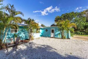 a blue house with palm trees in front of it at Sand Dollar Studio Pool Daily Rentals in Sarasota