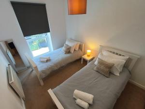 a bedroom with two beds and a window at Issara Apartments 49 - Great location & Private Parking in Portsmouth