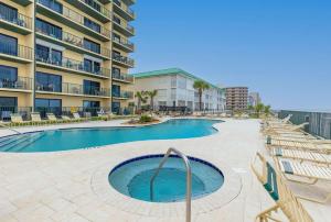 a swimming pool in front of a apartment building at Coastal Chic Suite at Sunglow Resort by Brightwild in Daytona Beach Shores