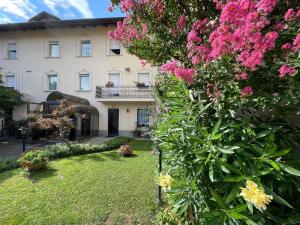 a garden with pink flowers in front of a building at Hotel & Residence Corona Grossa Balangero in Balangero