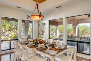 a dining room with a table and chairs and windows at Rancho Relaxo by PaseoHomesAZ with Pool, Spa and Separate Casita in Scottsdale