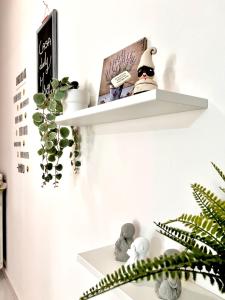 Lady Isa Casa Vacanza في كاستيلاماري دي ستابيا: رف أبيض على الحائط مع نبات