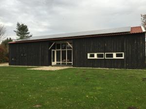 a black barn with windows and a grass field at Gastenverblijf Eindhoven, 6 persoons in Eindhoven