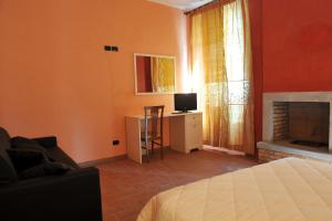 a bedroom with a bed and a desk with a television at Locanda Sant'Antonio de foris in Bergamo