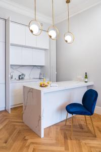a kitchen with a white counter and a blue chair at Old Town Heart XVIII - Downtown Luxury in Warsaw