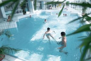 eine Gruppe von Personen, die in einem Schwimmbad schwimmen in der Unterkunft Hotel Am Medemufer in Otterndorf