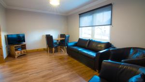 a living room with a couch and a table at Morris Gardens Apartments in Oldmeldrum