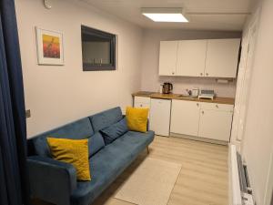 a living room with a blue couch and a kitchen at Moira Garden Tiny Home in Moira