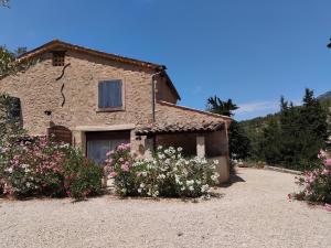 una casa di pietra con dei fiori davanti di 10 mn Buis les Baronnies a Plaisians