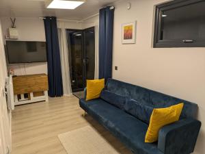 a living room with a blue couch and yellow pillows at Moira Garden Tiny Home in Moira
