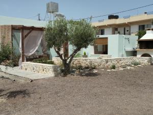 a house with a tree in front of a building at Pasiphae Luxury House in Ierapetra