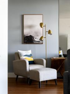 a living room with a chair and a lamp at Remodeled 3 Bedroom Oceanfront Condo — Sleeps 8 in Wailuku