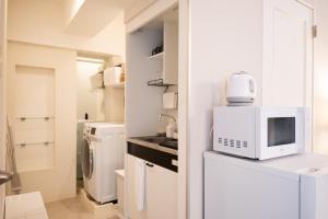 a kitchen with a microwave and a washer and dryer at RIVER CENTRAL HIROSHIMA - Vacation STAY 59342v in Hiroshima