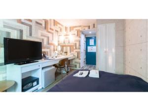 a room with a tv and a desk with a bed at Asuka Hotel - Vacation STAY 59966v in Karatsu +33 photos