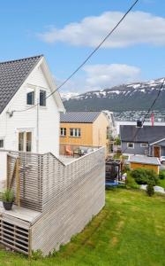 a white house with a fence in a yard at Aurora Stay- Aurora garden Apartment in Tromsø