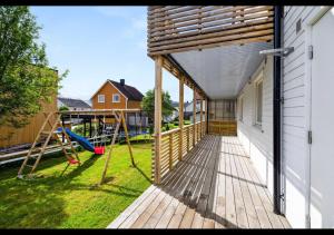 a deck with a playground on the side of a house at Aurora Stay- Aurora garden Apartment in Tromsø +1 photo