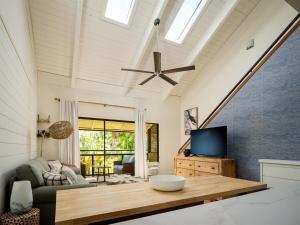 a living room with a ceiling fan and a tv at Newly Remodeled Luxury Condo — Sleeps 7 in Kihei