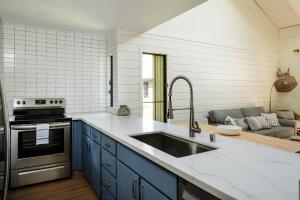 a kitchen with blue cabinets and a sink at Newly Remodeled Luxury Condo — Sleeps 7 in Kihei +19 photos