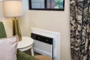 a room with a tv and a table and a lamp at Chic Beachfront Condo— Newly Remodeled — 2024 in Kihei