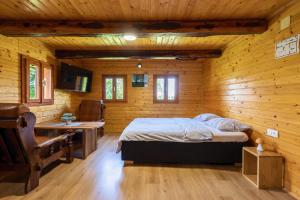a bedroom with a bed in a wooden cabin at Peace Creek in Slunj