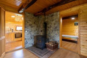 Zimmer mit einem Steinkamin in einem Blockhaus in der Unterkunft Peace Creek in Slunj
