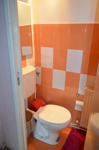 クルジュ・ナポカにあるCosy Studioのオレンジと白の壁の小さなバスルーム(トイレ付)