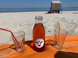 a bottle of beer and two glasses on the beach at Arkonablick 53 in Juliusruh