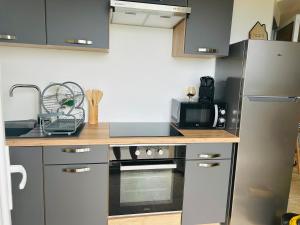 a small kitchen with a stove and a refrigerator at I pozzi jacuzzi furiani love room haute corse in Furiani