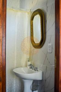 a bathroom with a sink and a mirror on the wall at Casa Parvati Chapadmalal in Chapadmalal +4 photos