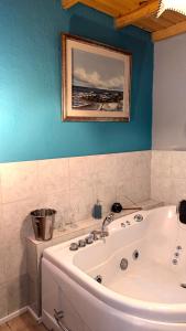 a bathroom with a white tub and a painting on the wall at Entre naturaleza a 1 cuadra de la playa/Jacuzzi in Salinas  +20 photos