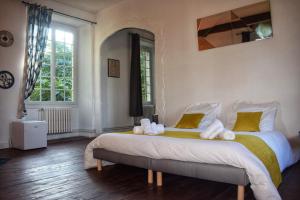 a bedroom with a large bed with yellow and white pillows at Elégance Périgourdine and SPA in Sainte-Sabine +38 photos