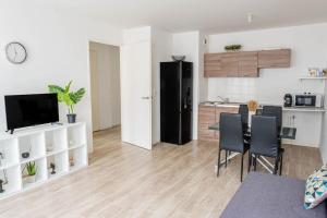 eine Küche und ein Wohnzimmer mit Tisch und Stühlen in der Unterkunft L'escapade confortable in Le Blanc-Mesnil + 1 Foto