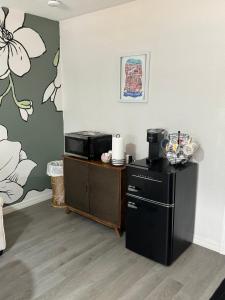 a kitchen with a microwave and a refrigerator at The Sanford Foodie Guest House in Sanford