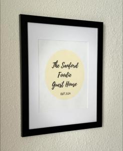 a framed picture of a sign on a wall at The Sanford Foodie Guest House in Sanford