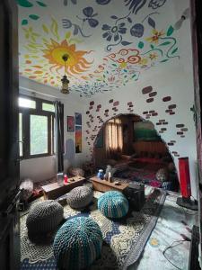 a room with a room with a wall with flowers on it at Eye love peace cafe in Manīkaran
