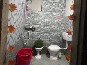 a bathroom with a toilet and a plant in it at Eye love peace cafe in Manīkaran
