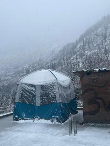 a tent is covered in snow on a mountain at Eye love peace cafe in Manīkaran +8 photos