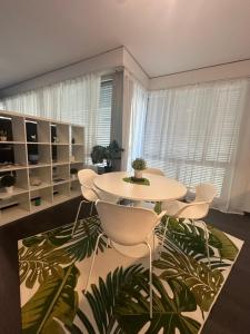 a room with a table and chairs in a room with plants at LuganoApartment in Lugano