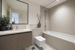 a bathroom with a tub and a toilet and a sink at High-Rise Chic, Burj Crown, Opera Boulevard View, by Dubai Mall in Dubai