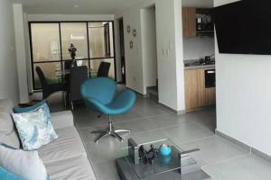 un salon avec un canapé et une chaise bleue dans l'établissement Linda casa en El Edén Tebaida Quindío Armenia, à La Tebaida