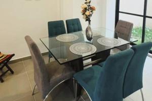 une table de salle à manger avec des chaises et un vase avec des fleurs dans l'établissement Linda casa en El Edén Tebaida Quindío Armenia, à La Tebaida