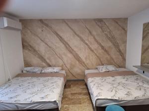 two beds in a room with a wall at Stan na dan Berane in Berane