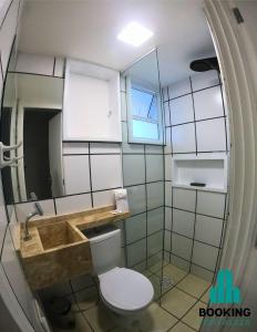 a bathroom with a toilet and a sink and a mirror at Estoril Praia de Iracema in Fortaleza