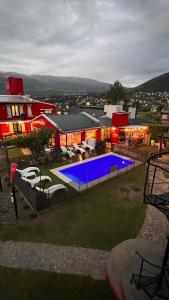 a house with a swimming pool in front of a building at Apart del Valle in Tafí del Valle