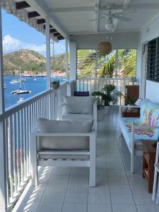 a porch with a couch and a view of the water at La Sucrière in Terre-de-Haut