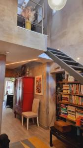 a living room with a book shelf and a staircase at The Coolest Place near the airport! in Lisbon +7 photos