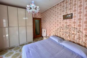 Un dormitorio con una cama grande y una lámpara de araña. en ALFA Holidays, en Sorrento